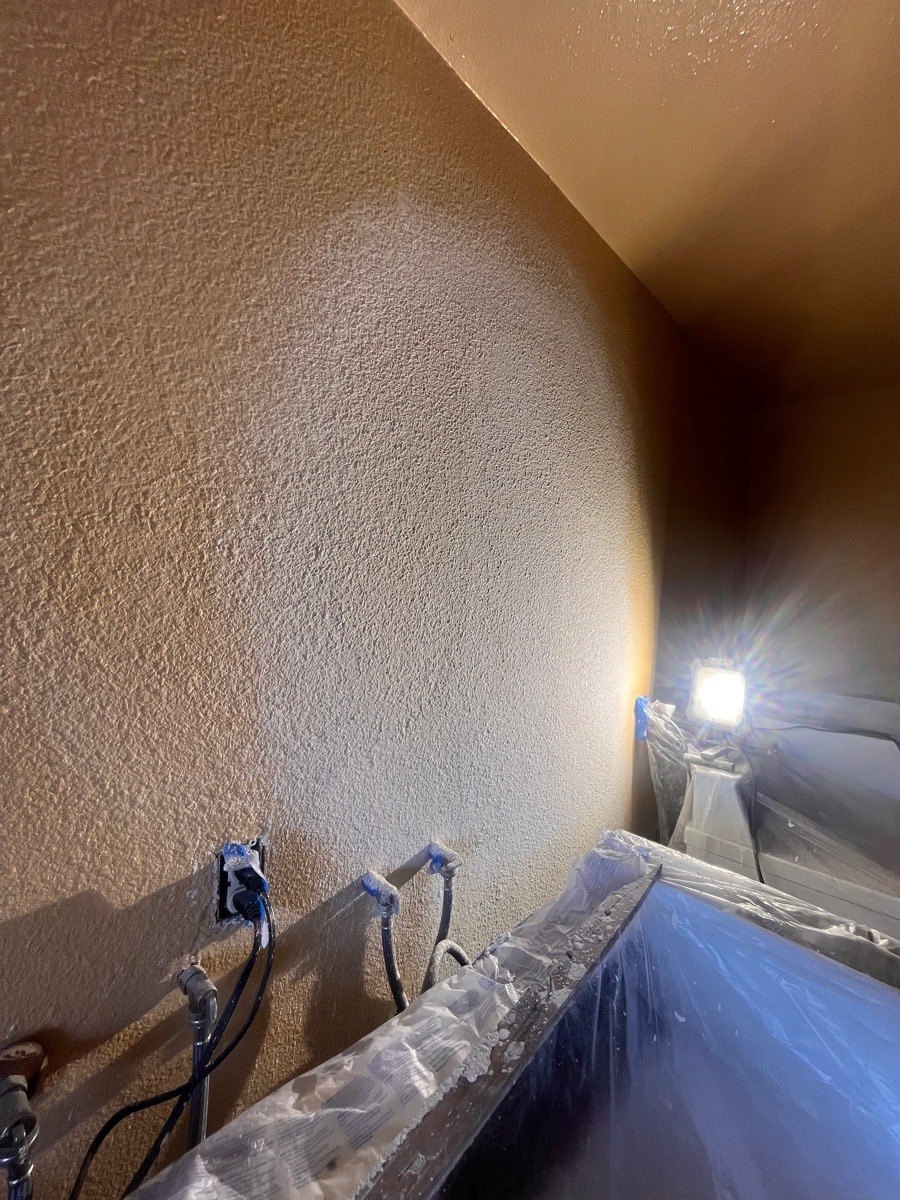 Wall-restoration stage with texture work and protected surroundings.